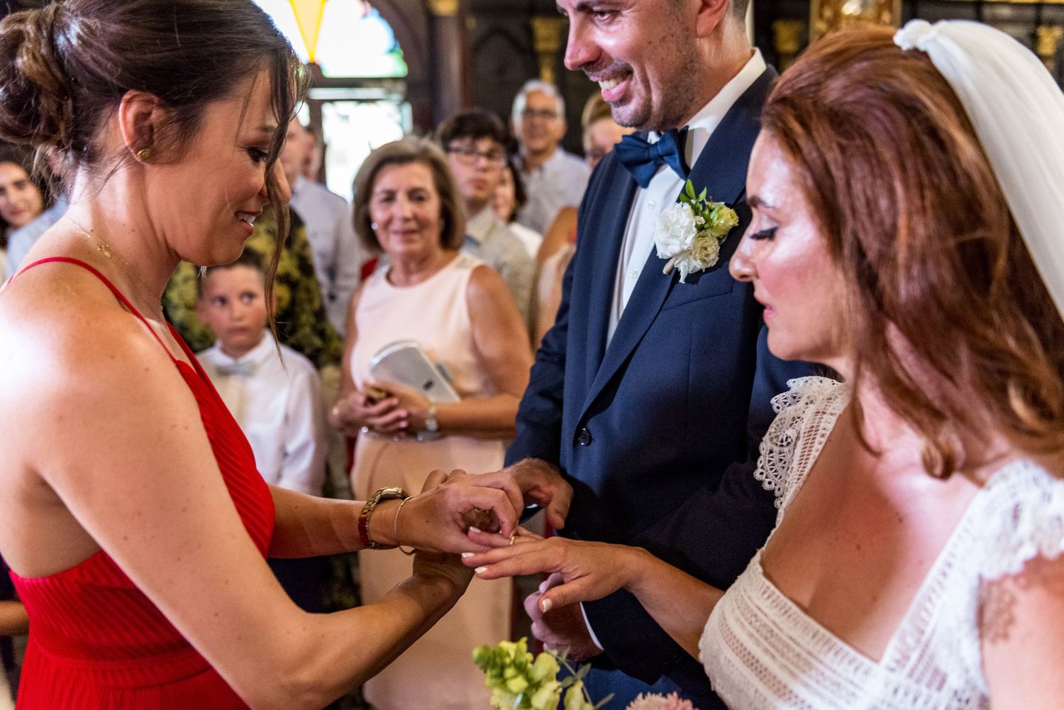 Wedding ceremony guests gather in an ornately decorated historic venue.