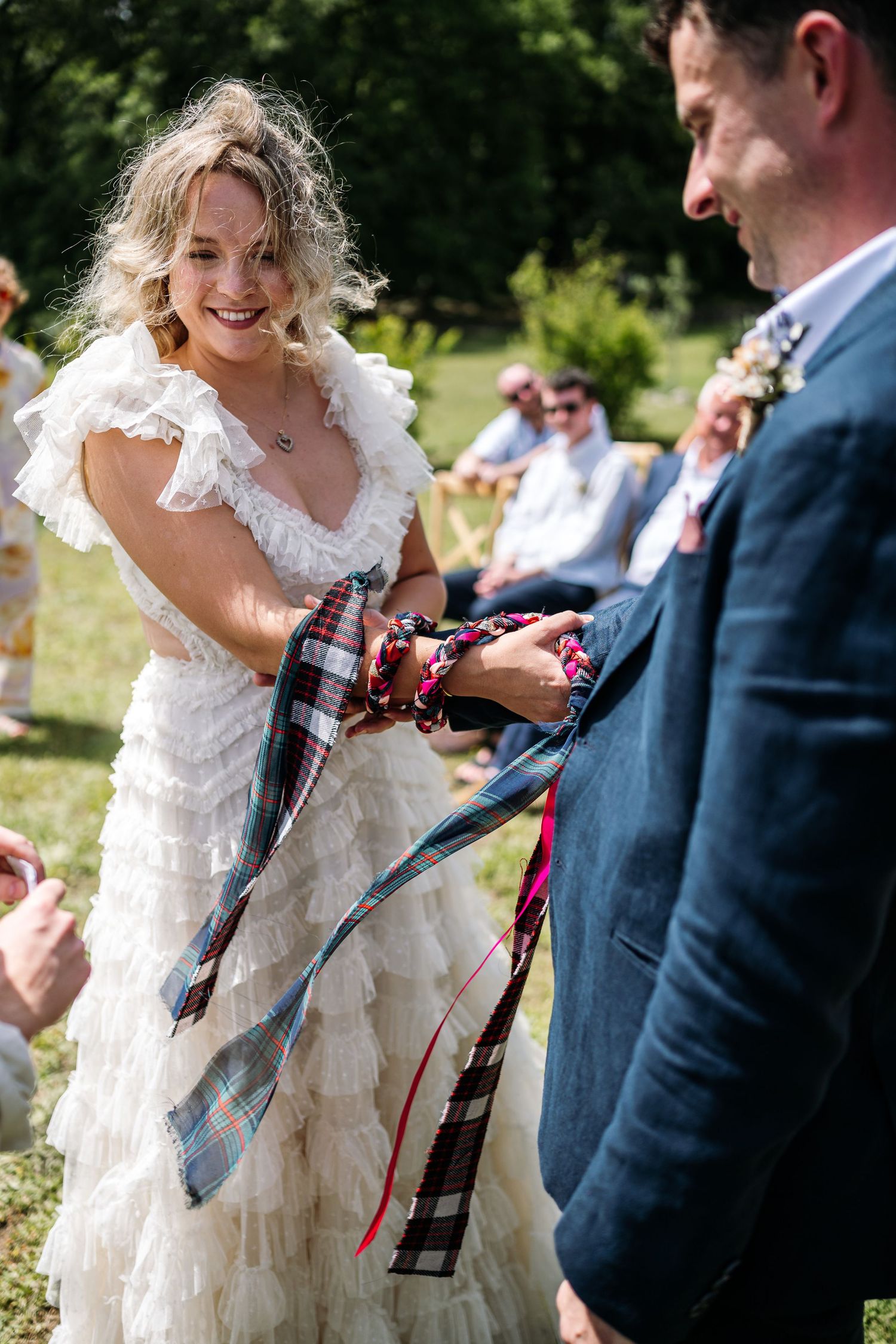 Newlyweds share playful moments with props during their outdoor wedding photoshoot.