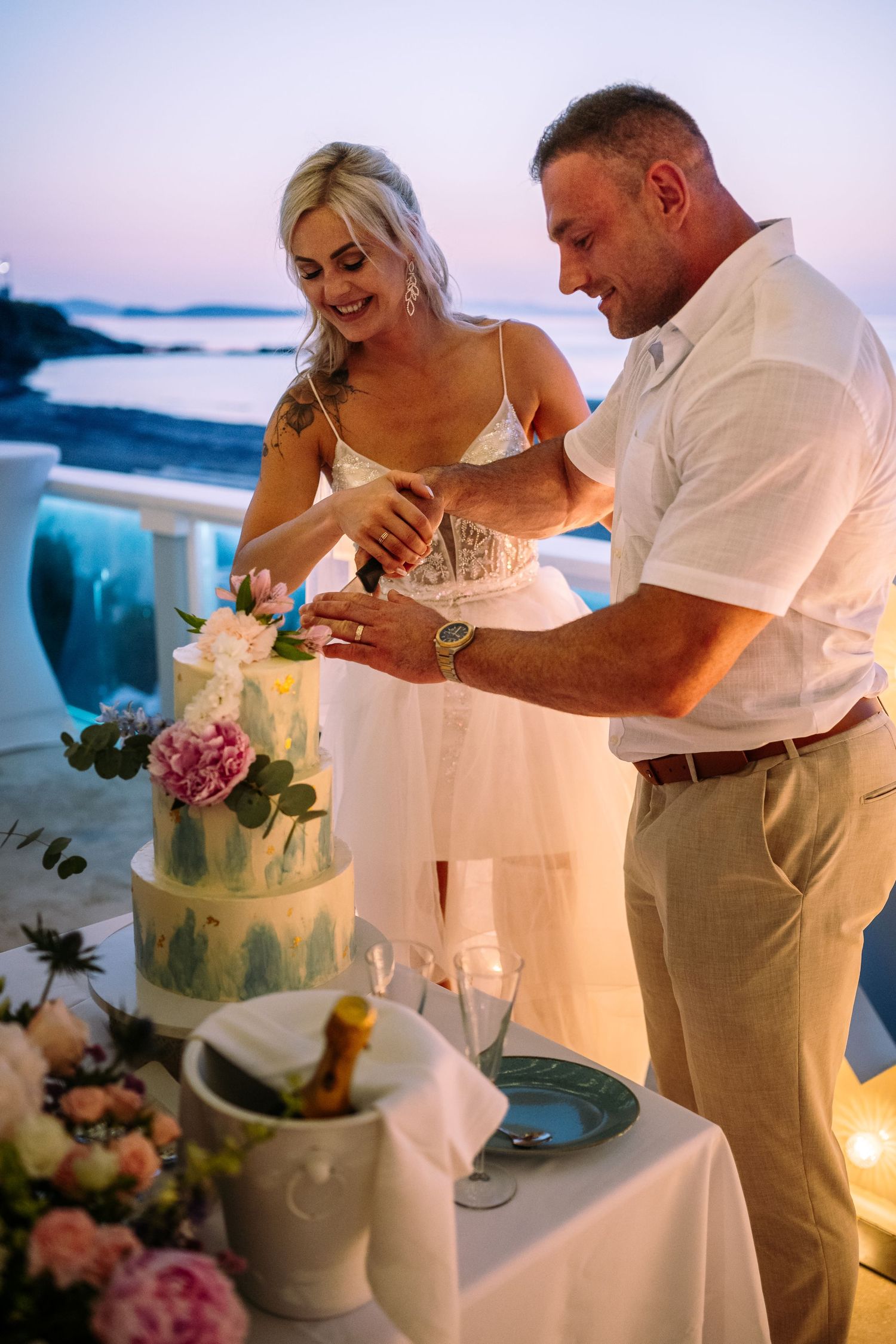 Couple cutting their blue watercolor wedding cake during reception.