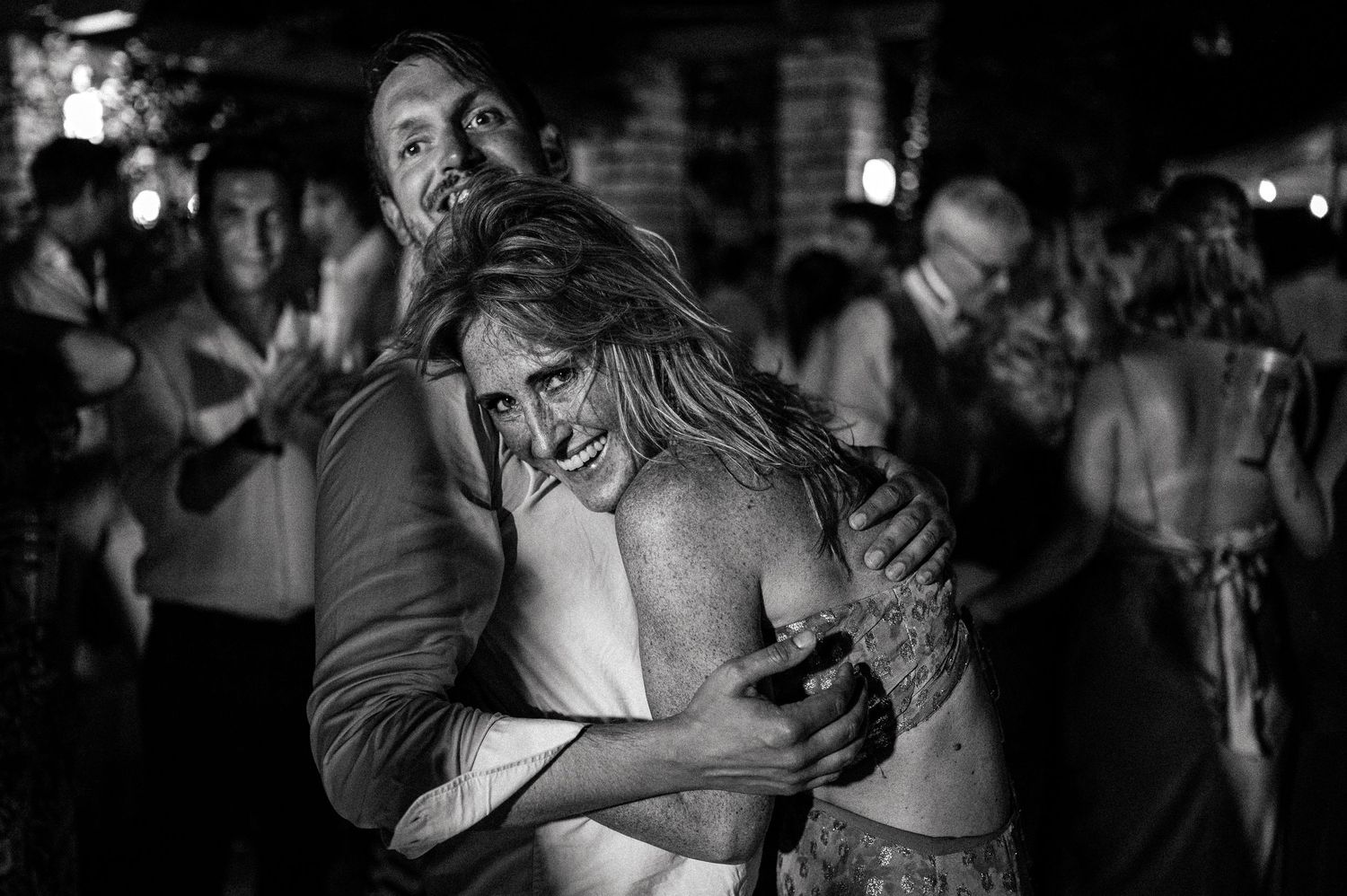 Black and white photo of couples dancing closely at an evening celebration.