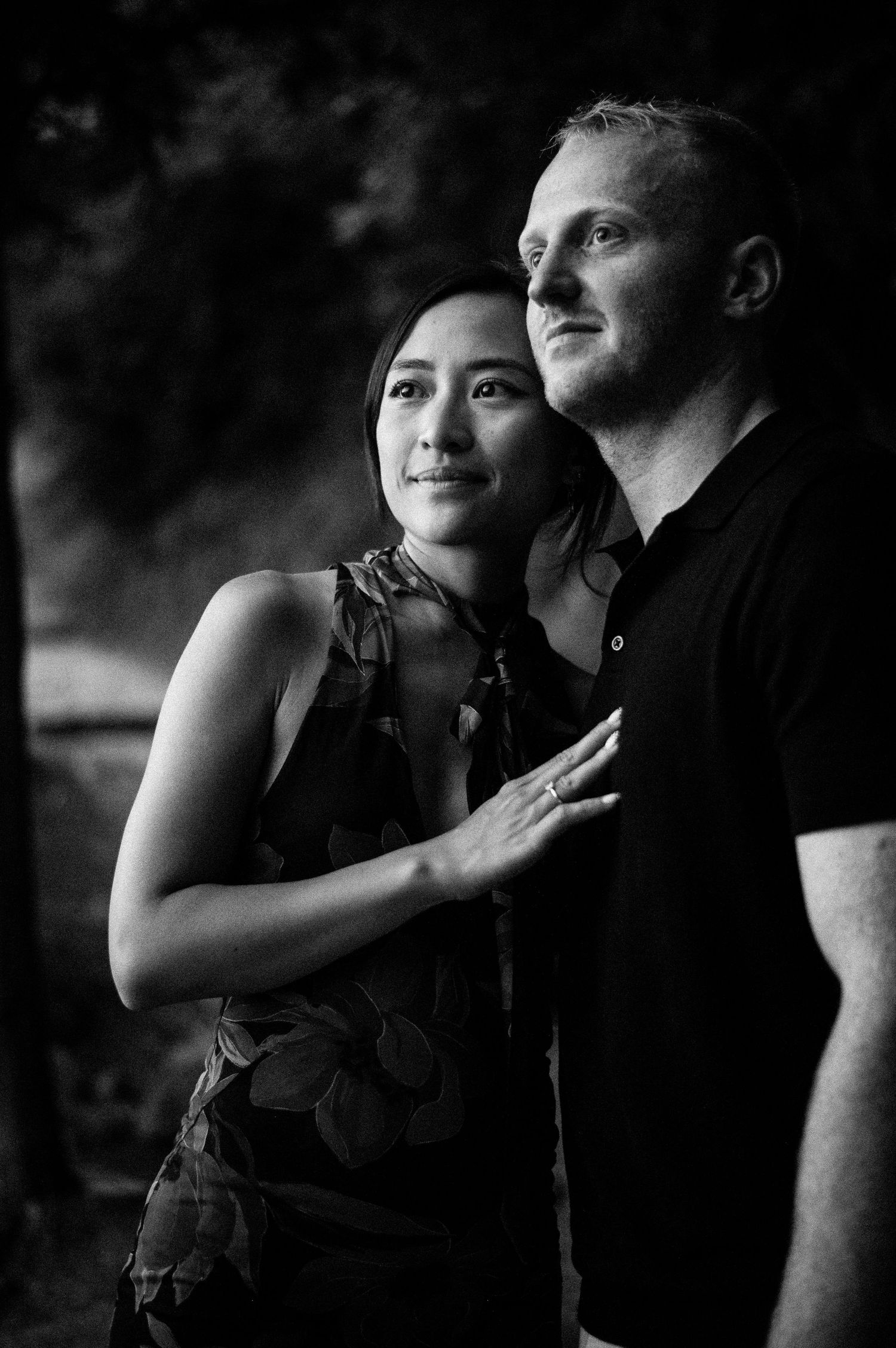 Intimate black and white portrait of couple in dramatic lighting.