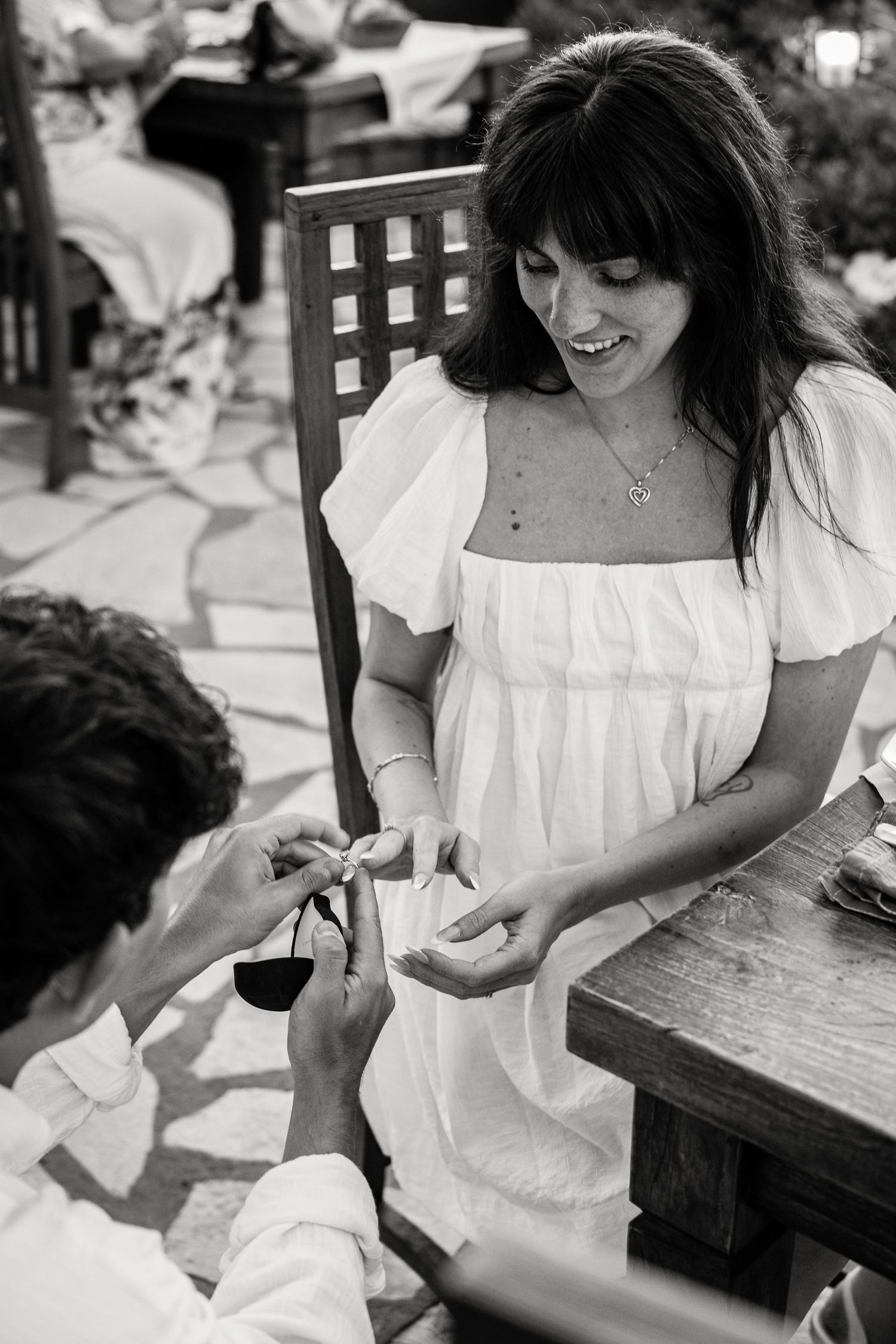 Black and white sequence of hands writing or drawing at wooden table.