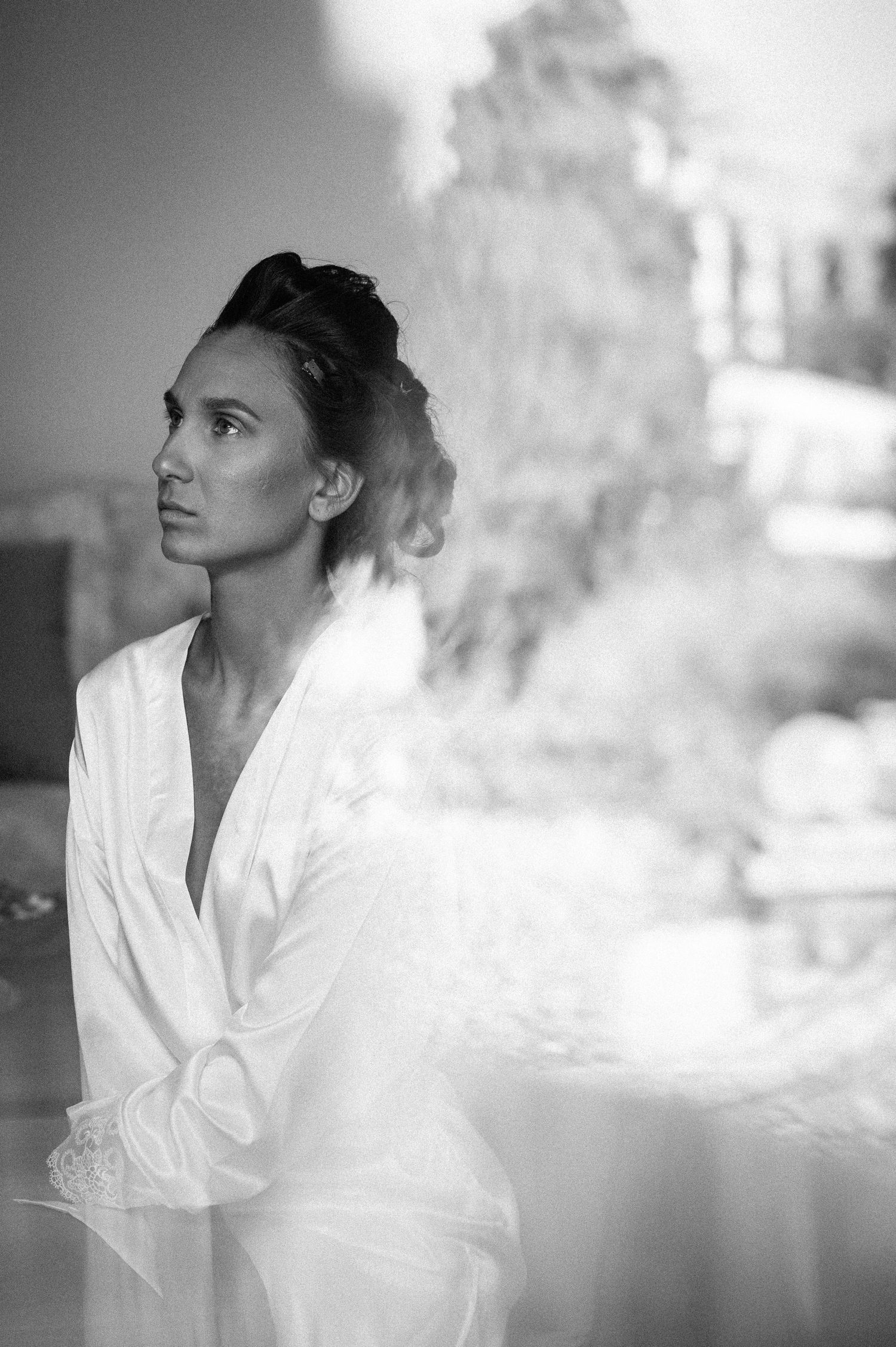 Artistic black and white portraits in soft lighting wearing a white robe.