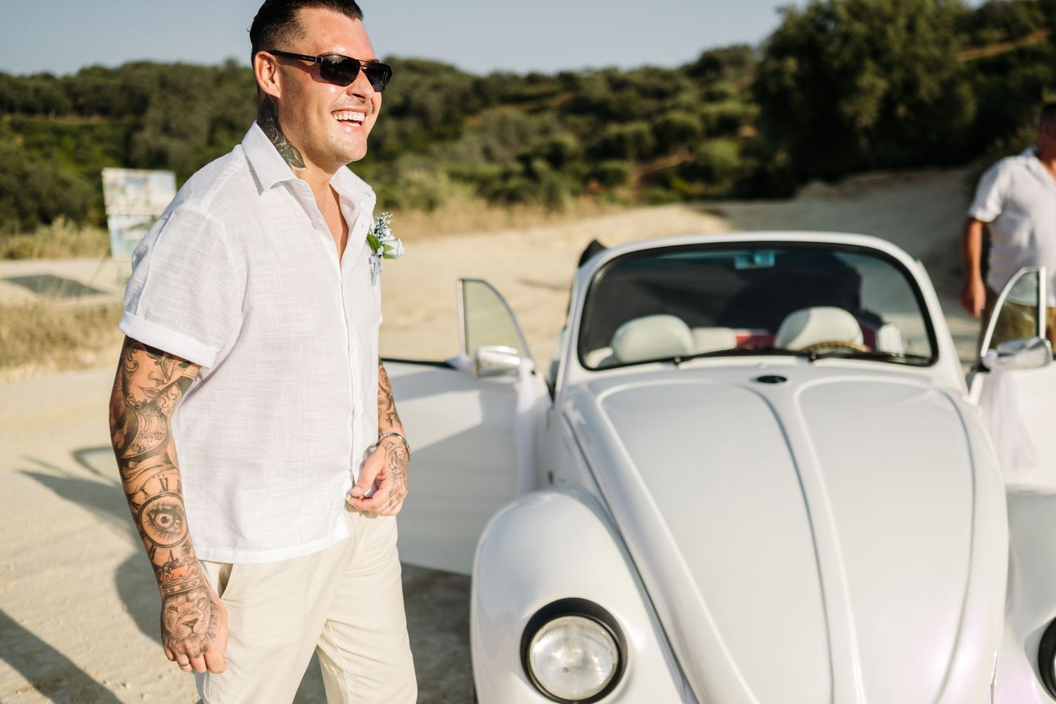 Vintage silver Volkswagen Beetle decorated for a beach wedding ceremony.