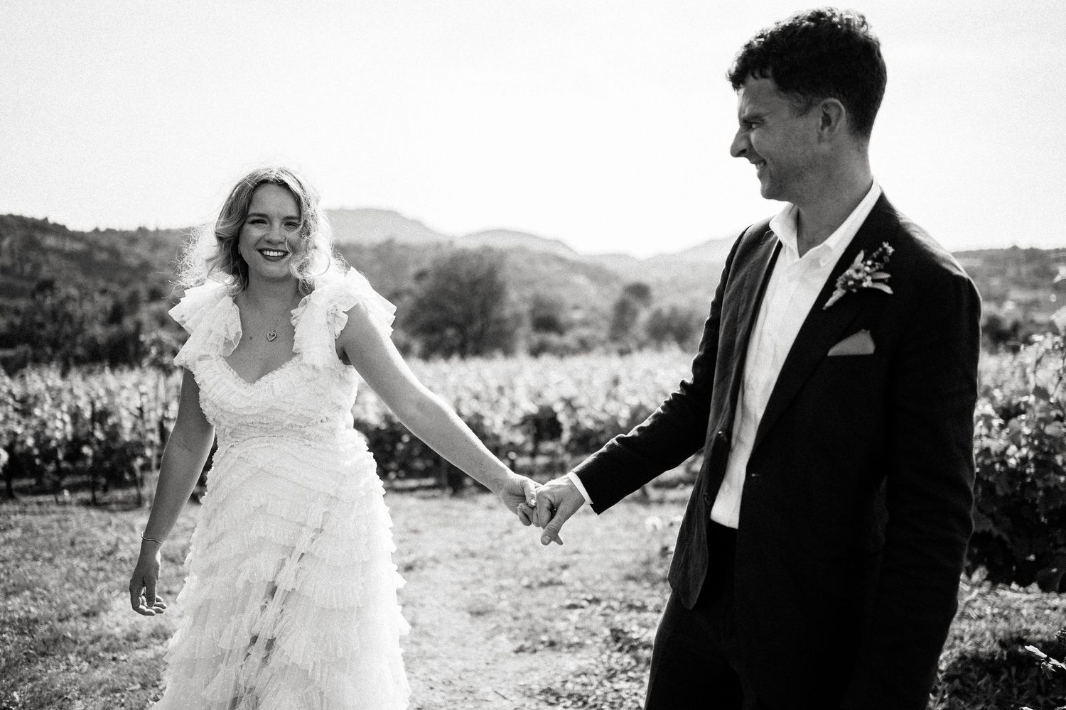 Romantic couple portraits captured against mountain vineyard backdrop.