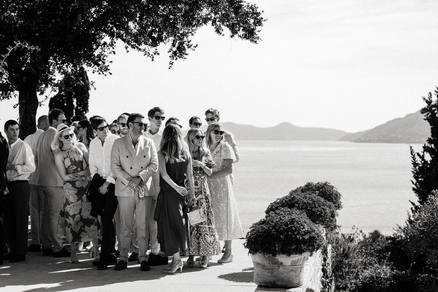 Black and white panoramic of wedding ceremony overlooking coastal view.