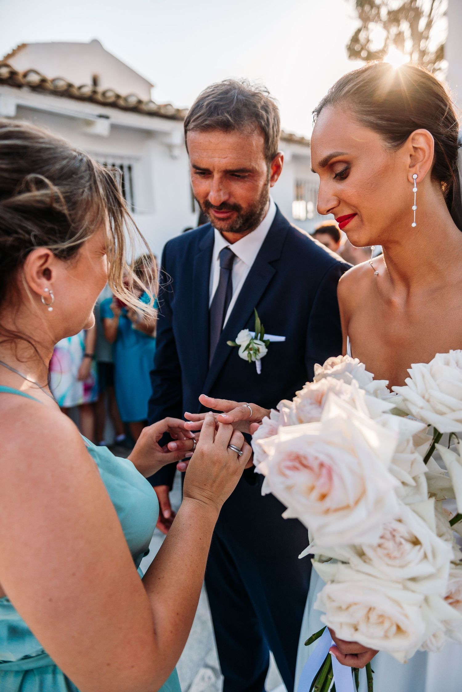 Emotional wedding moments shared between couple with white rose bouquet.