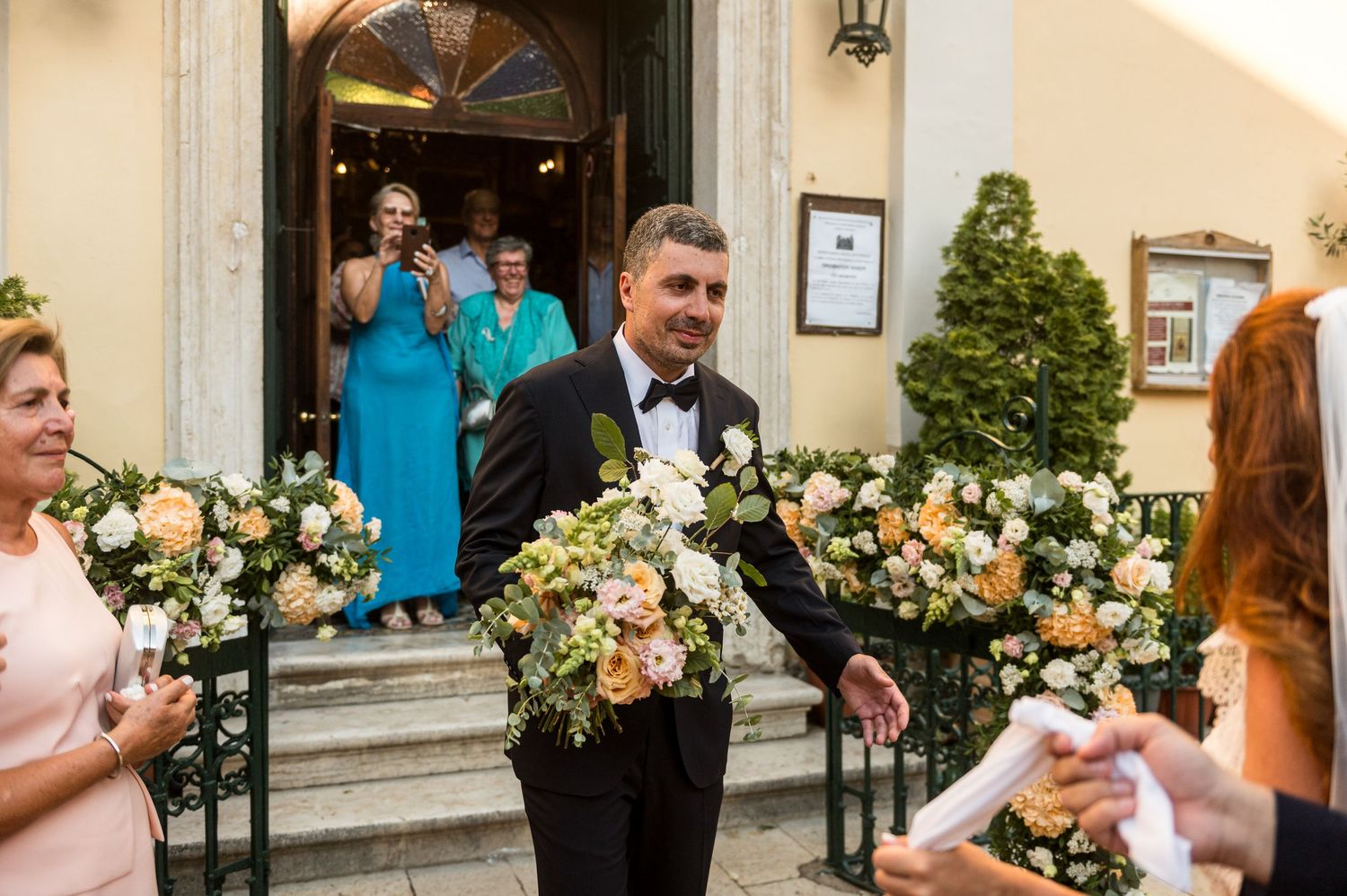 Elegant floral arrangements decorate the entrance of a traditional wedding venue.