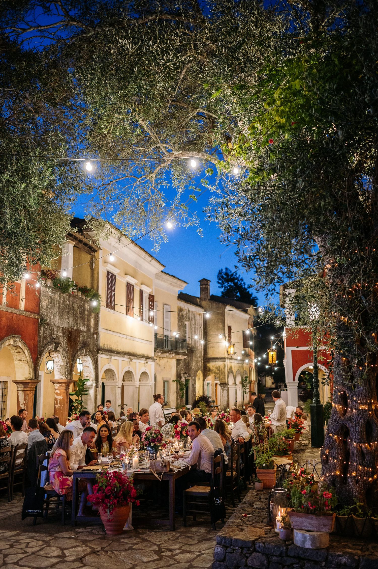 Charming street scene with string lights illuminating historic buildings during an evening celebration.