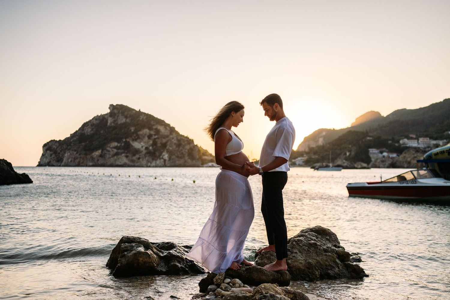 Romantic seaside photoshoot with dramatic coastal landscape during golden hour.