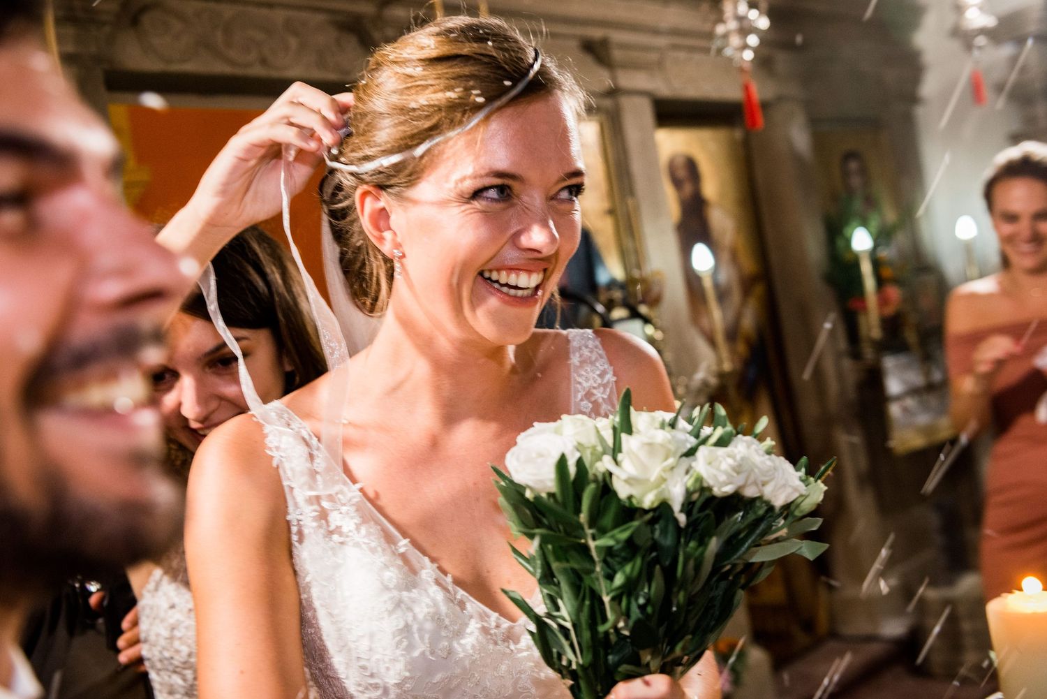 Candid moment of joy during wedding celebration with white roses and indoor lighting.