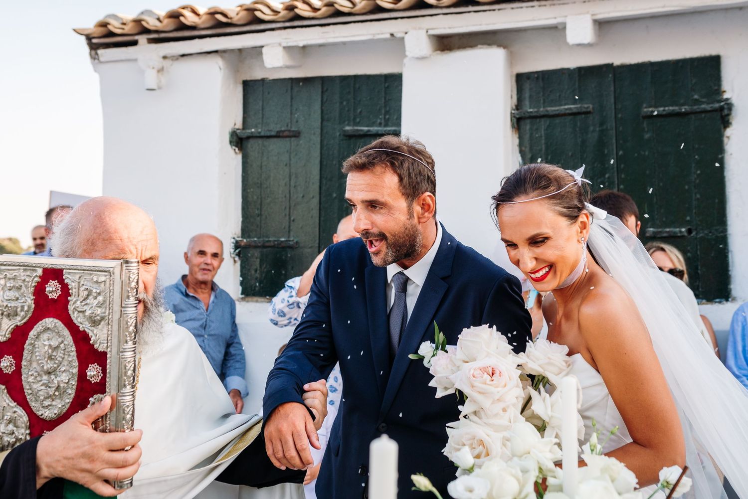 Festive wedding celebration with Spanish architecture and terracotta roof tiles visible.