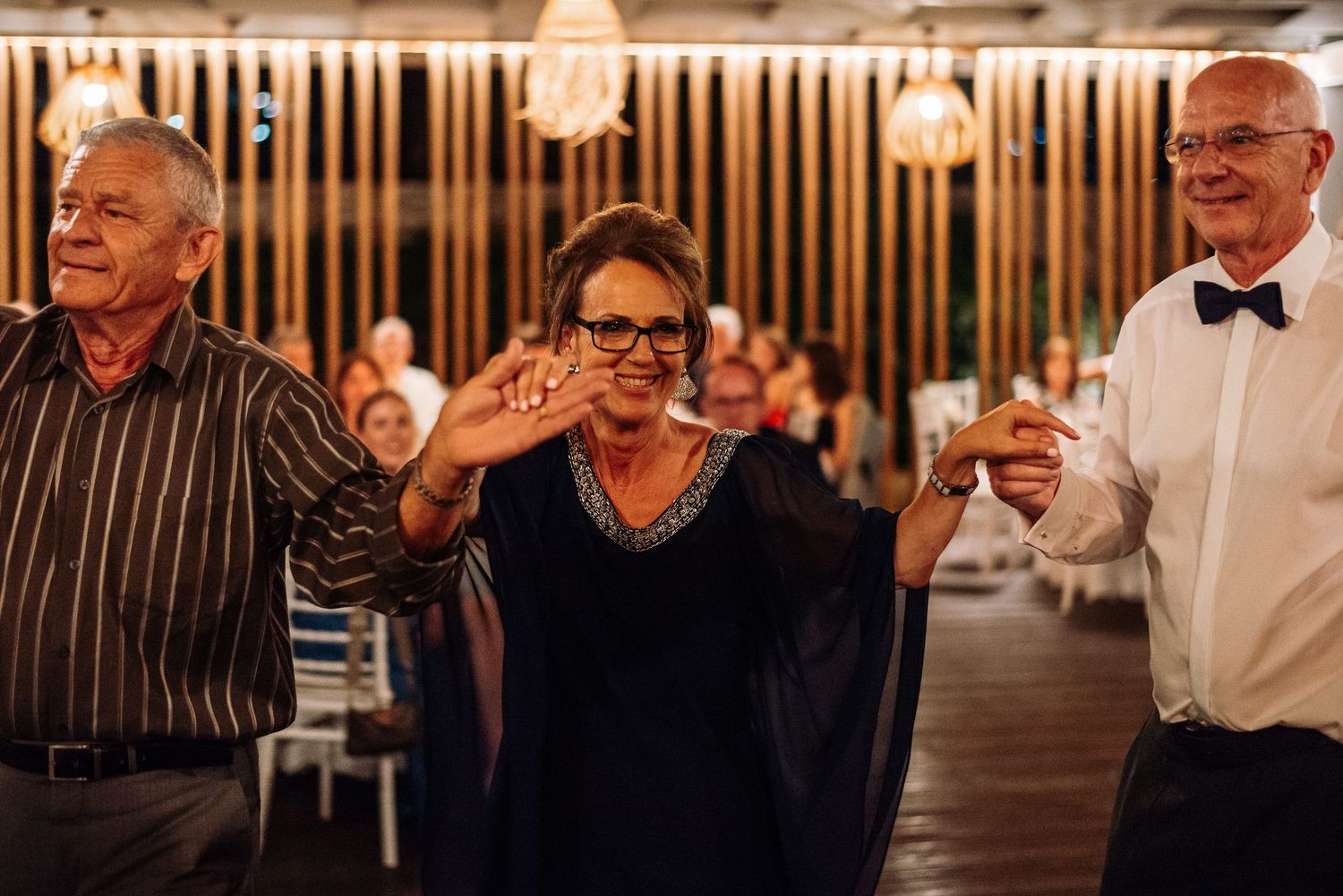 Evening wedding reception with guests enjoying festivities under warm lighting.
