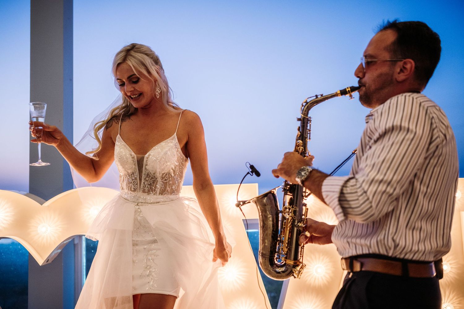Wedding celebration with live saxophone music and champagne toasts.