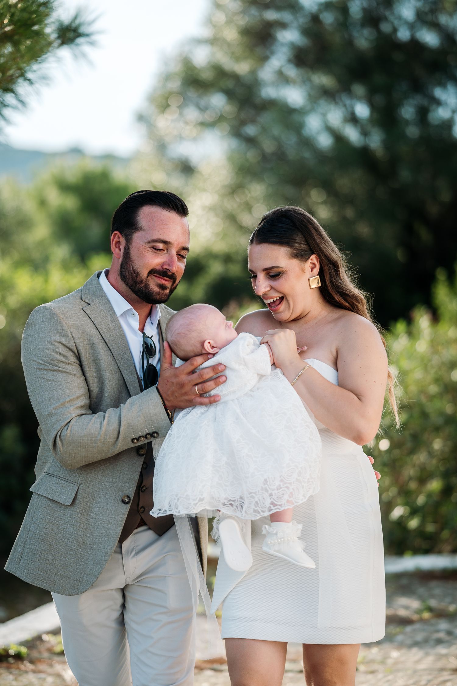 Joyful family portraits taken outdoors with natural greenery in the background.