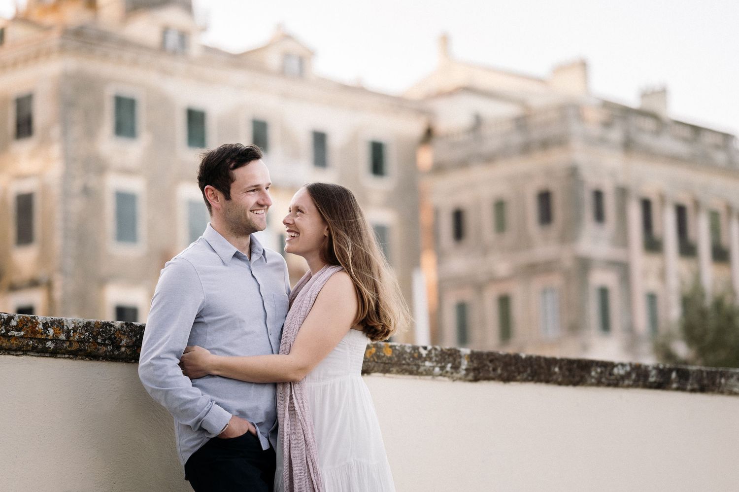 Romantic couple photoshoot in front of historic Mediterranean architecture.