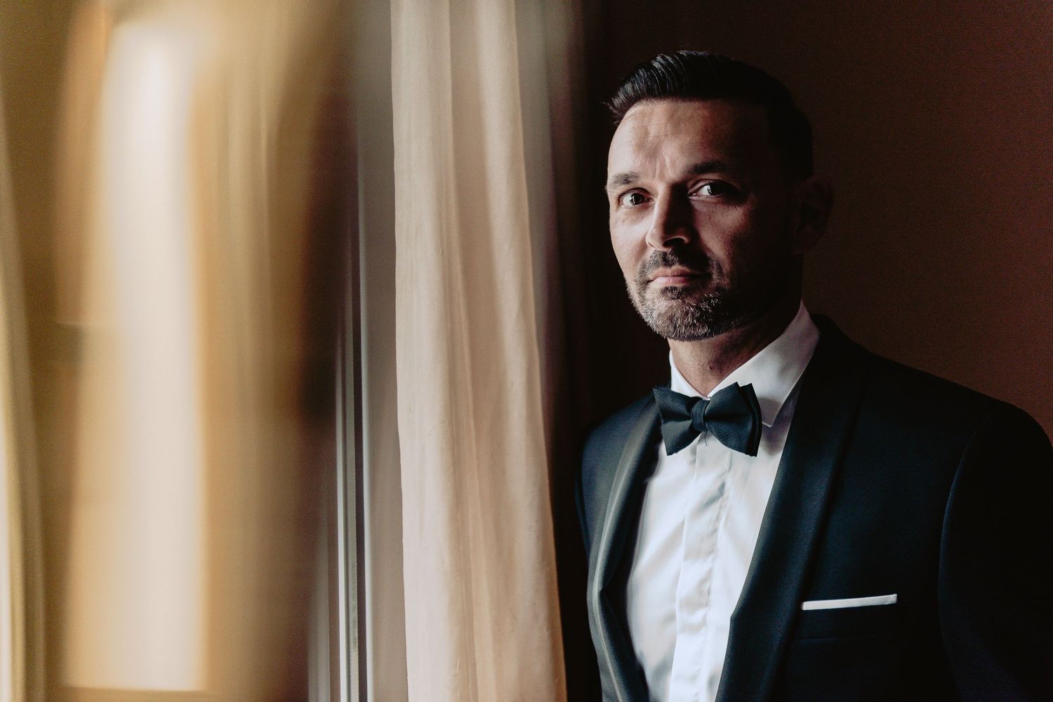 Close-up portraits of formal attire and wedding day preparations in warm lighting.