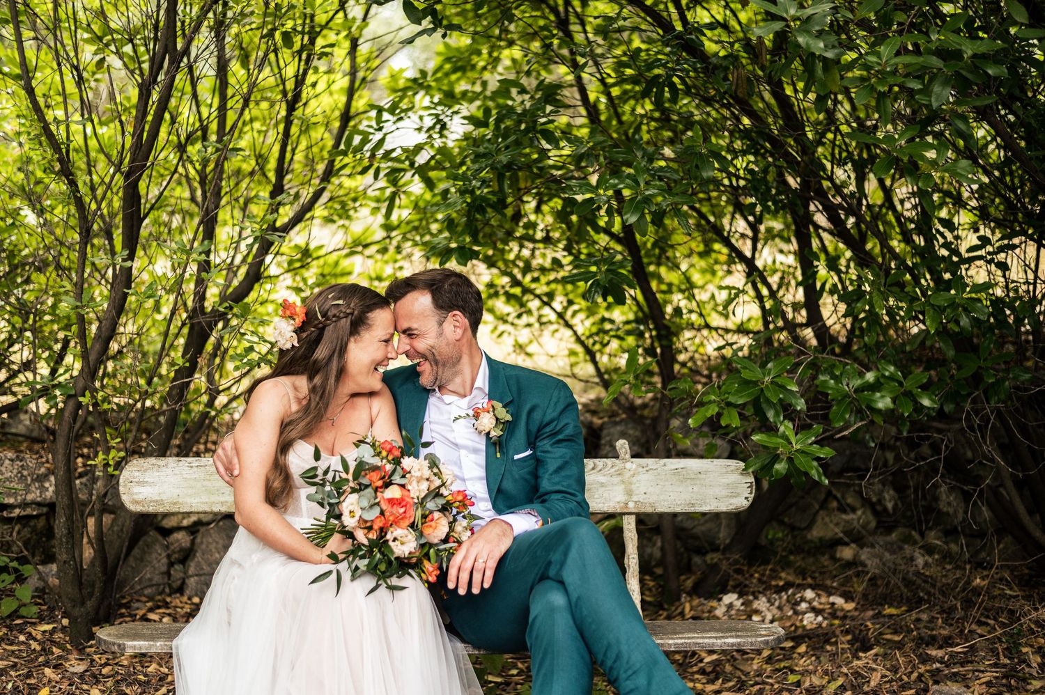 Romantic wedding portraits in a sunlit garden with natural greenery.