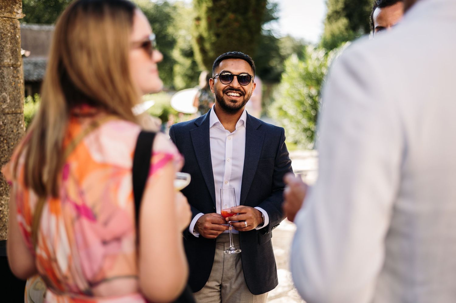 Wedding guests mingle and socialize at an outdoor summer reception.