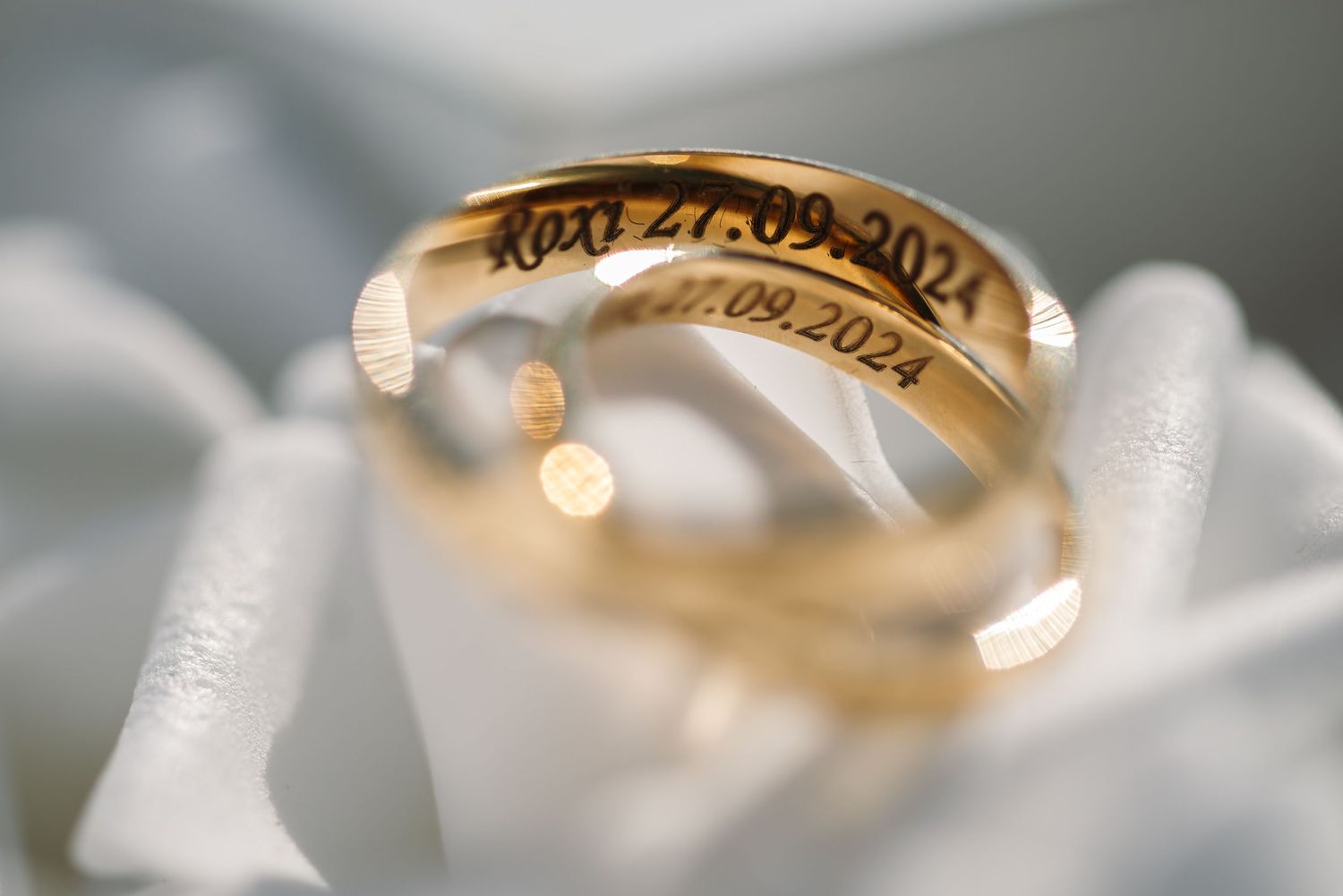 Macro shot of golden wedding rings with delicate engraving details.