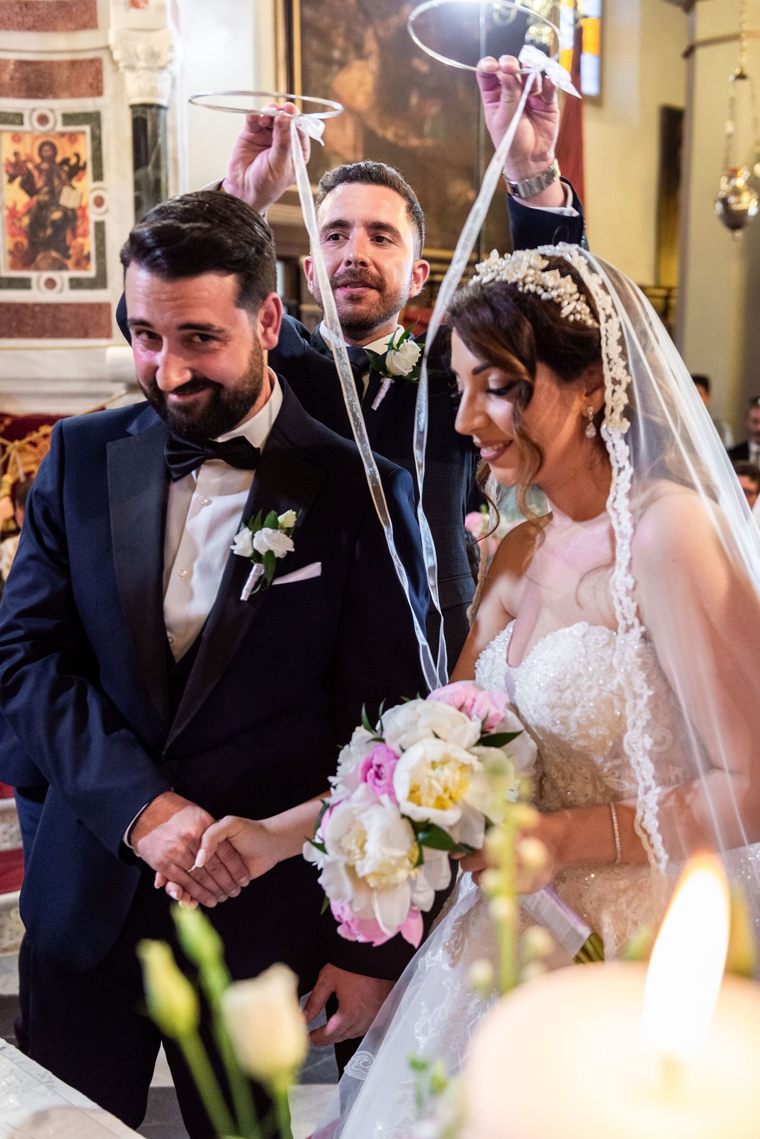 Wedding ceremony moments captured in a traditional church setting with candles.