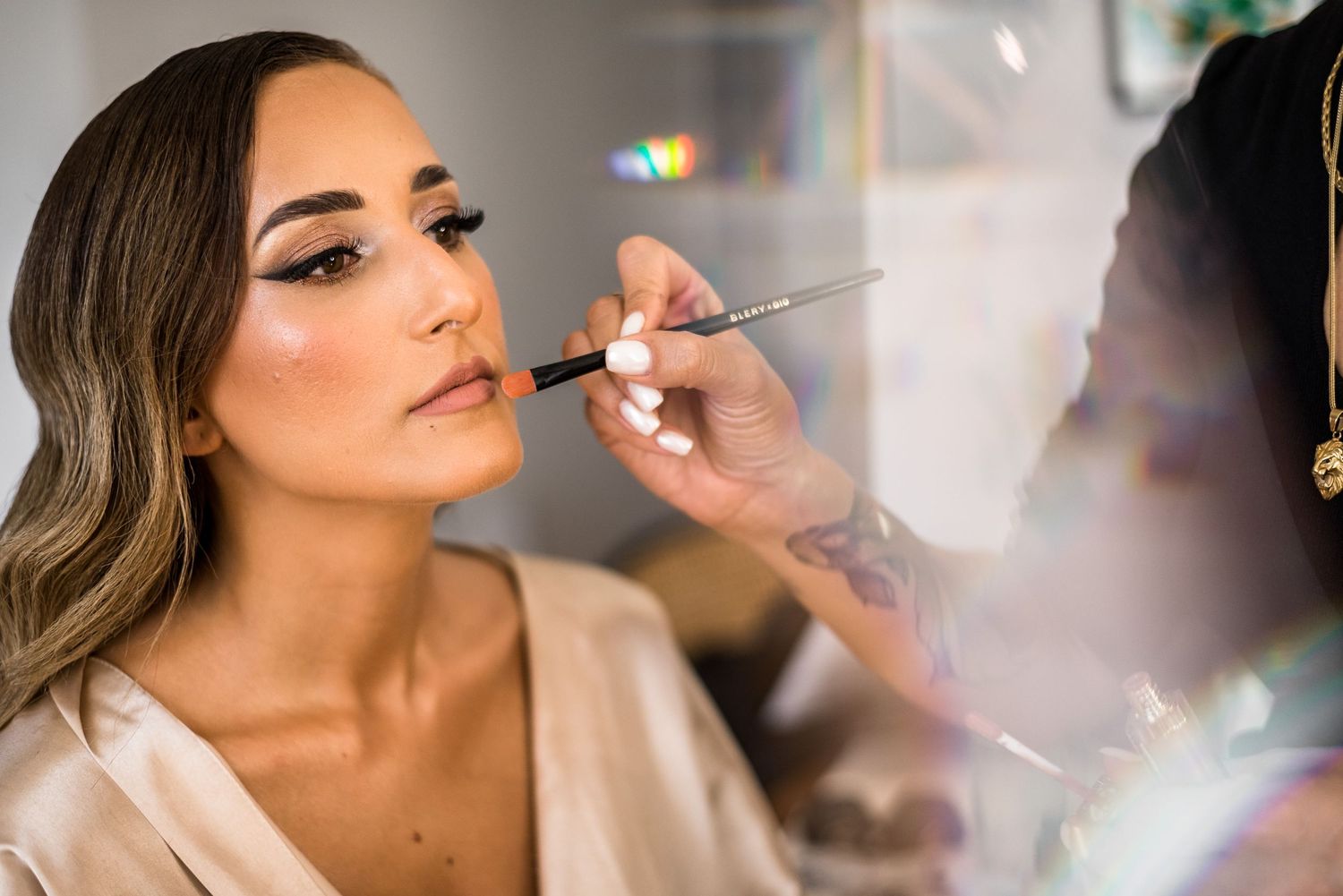 Wedding day preparation scene with soft natural lighting and makeup application.