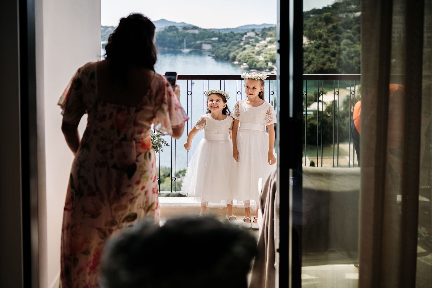 Wedding preparation scene with view of ocean through balcony doors.