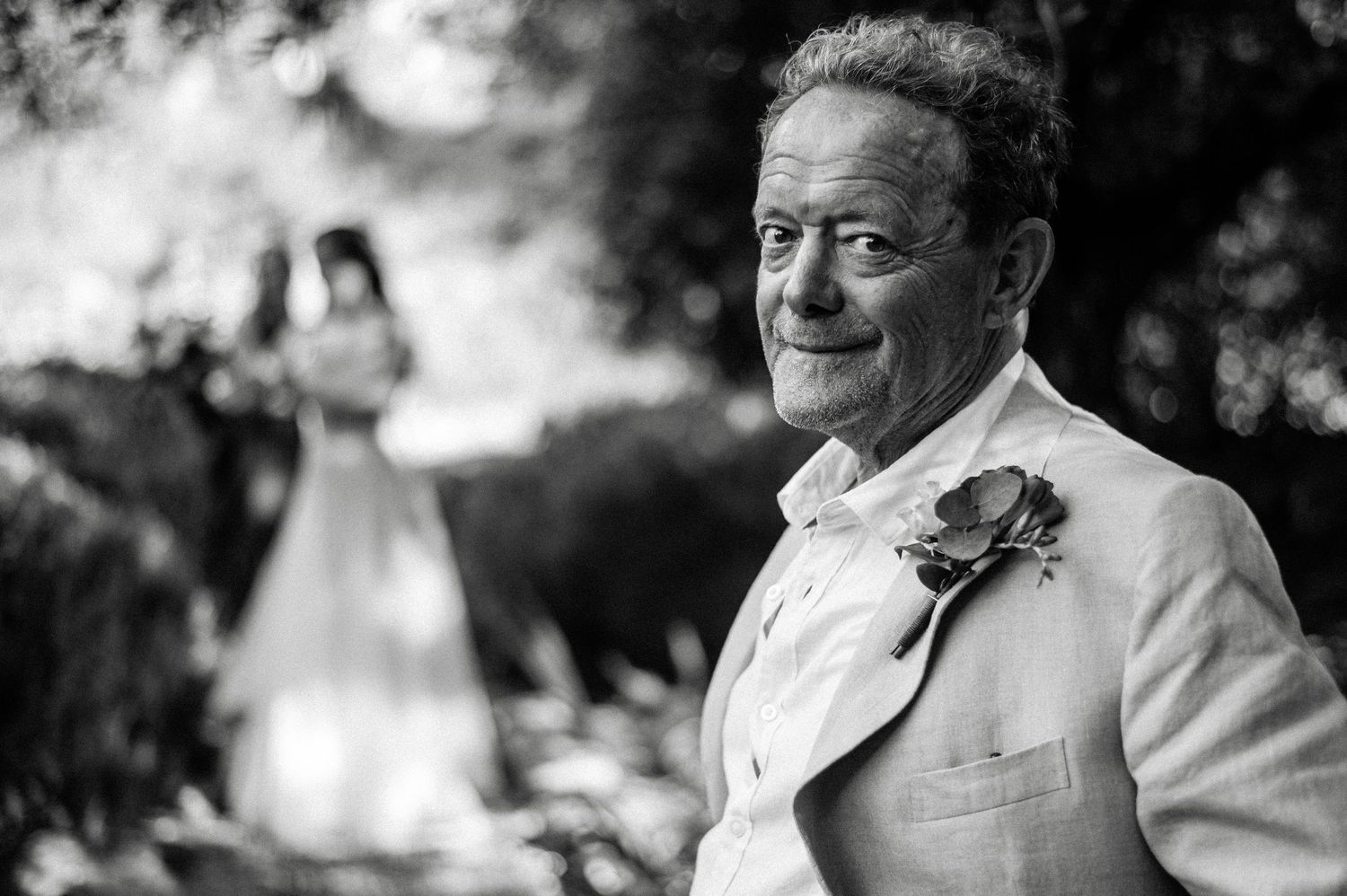 A joyful outdoor wedding celebration with guests smiling and mingling in a garden setting.