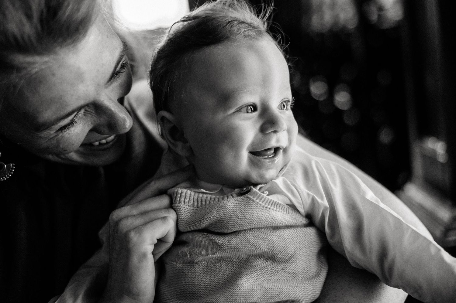 Black and white candid portrait showing joyful moment between parent and child.