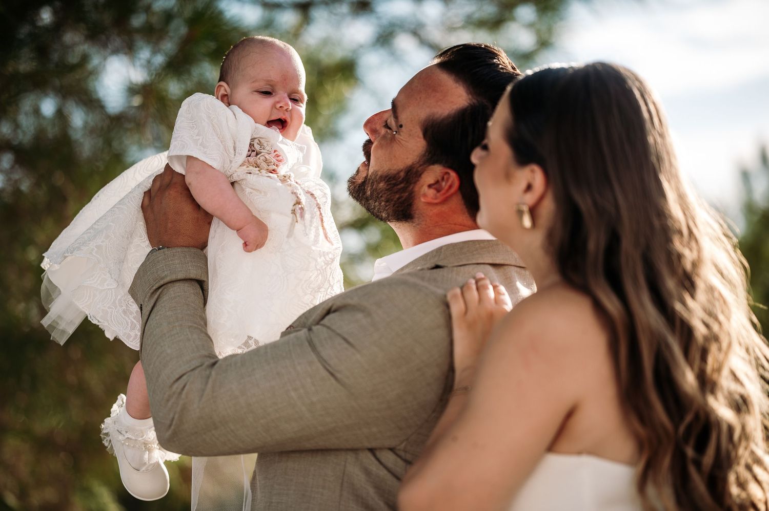 Tender family moment captured outdoors in warm natural lighting.