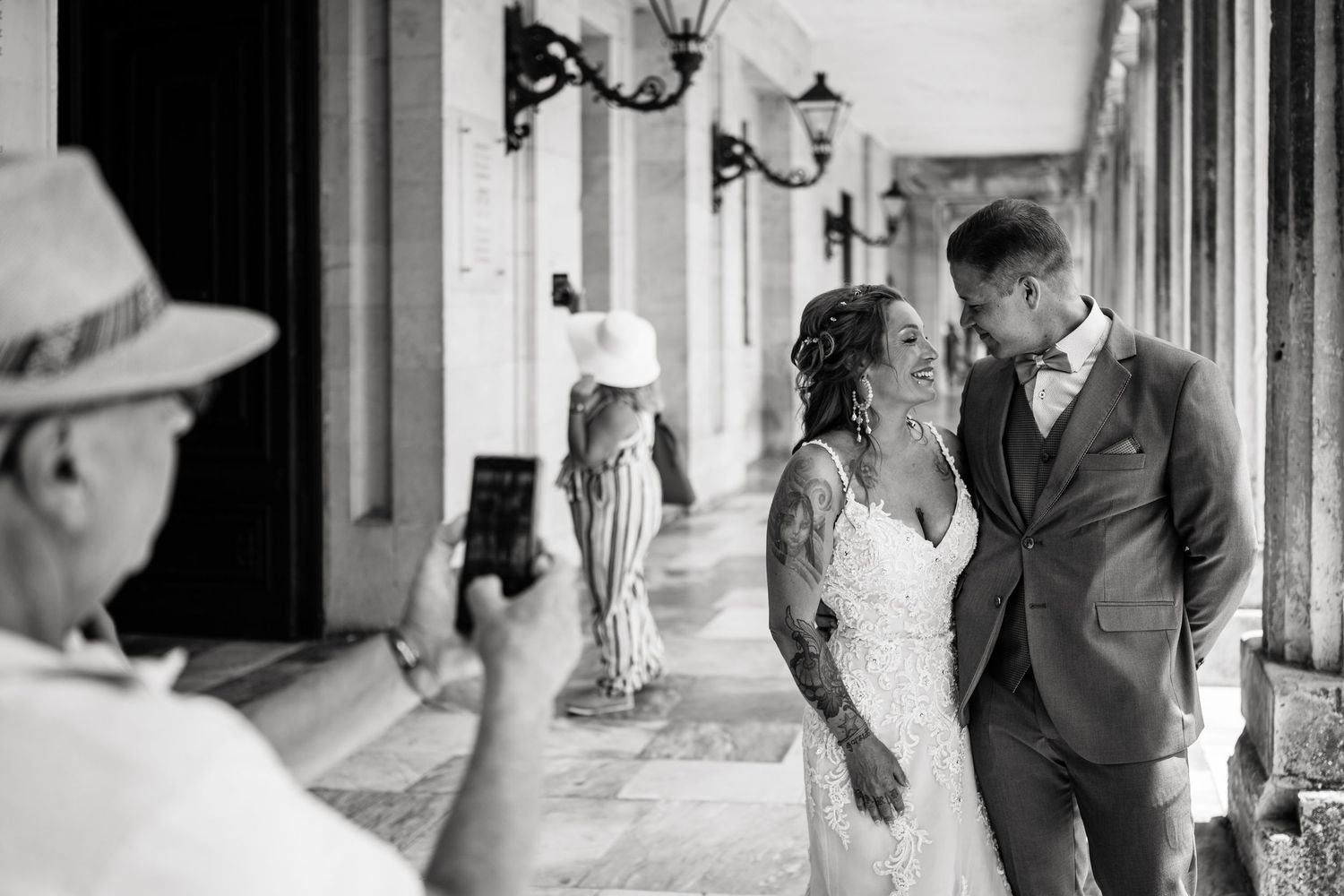 Black and white wedding photos capturing tender moments in an elegant hallway.