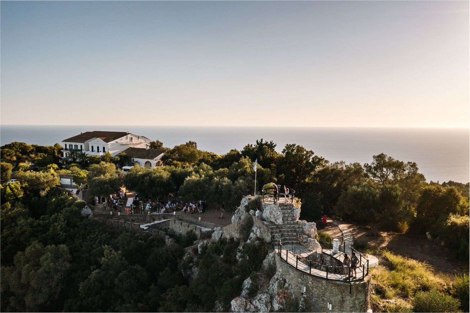 Panoramic view of a Mediterranean coastal villa perched on dramatic white cliffs at sunset.