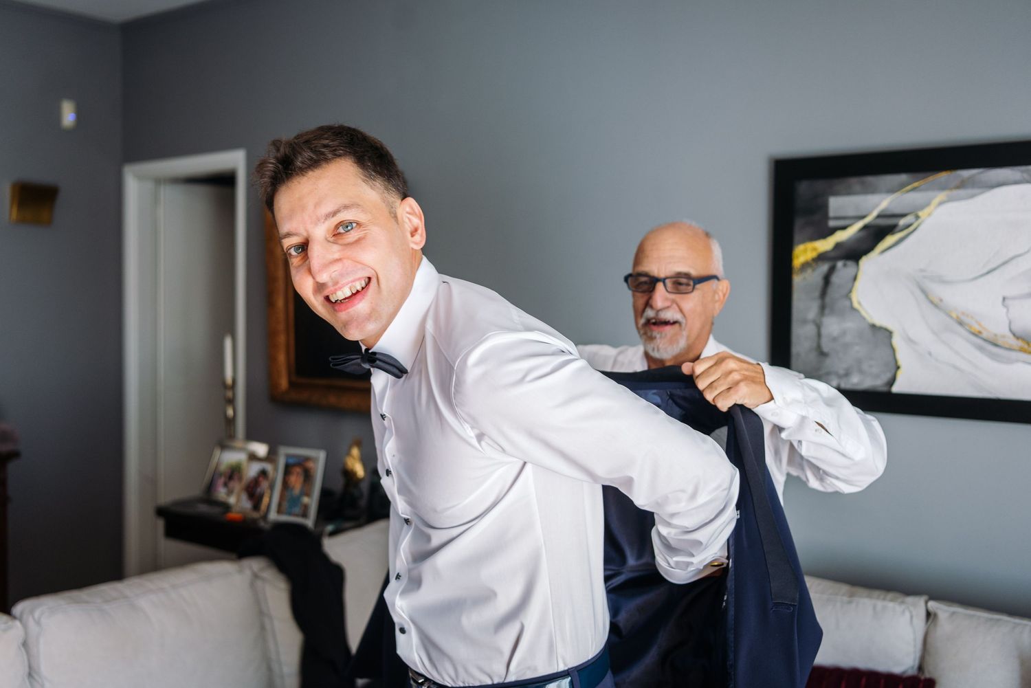People in white shirts preparing in a room with gray walls and natural light.