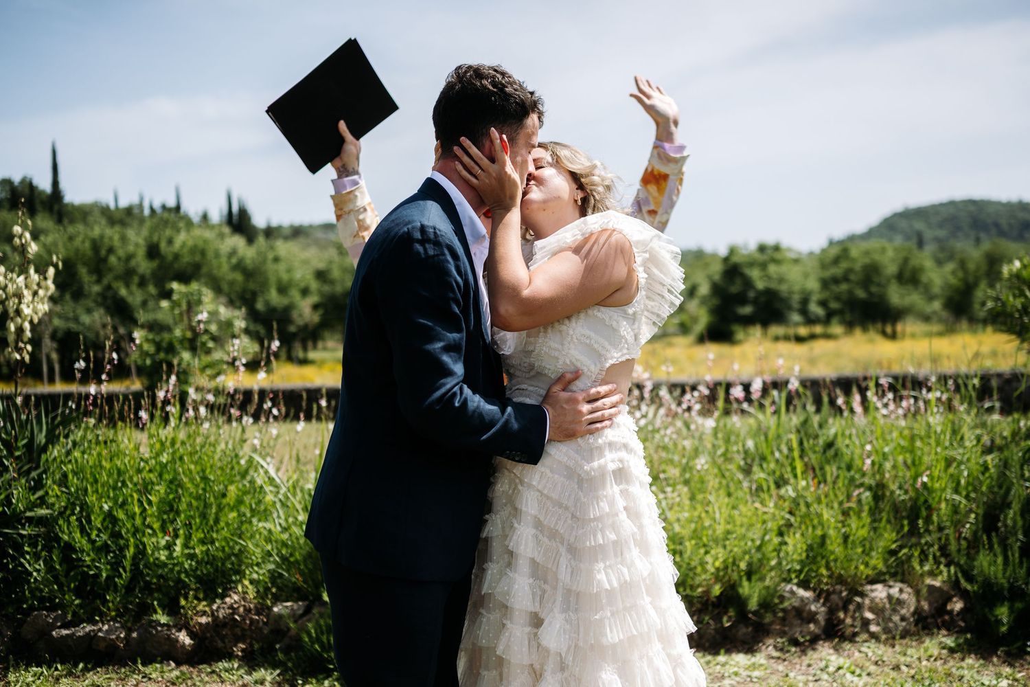 Romantic wedding moments unfold against a backdrop of rolling hills and cypress trees.