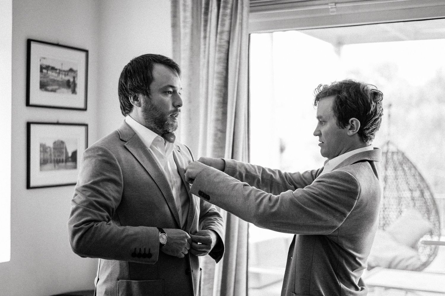 Sequence showing two people in suits adjusting each other's ties.
