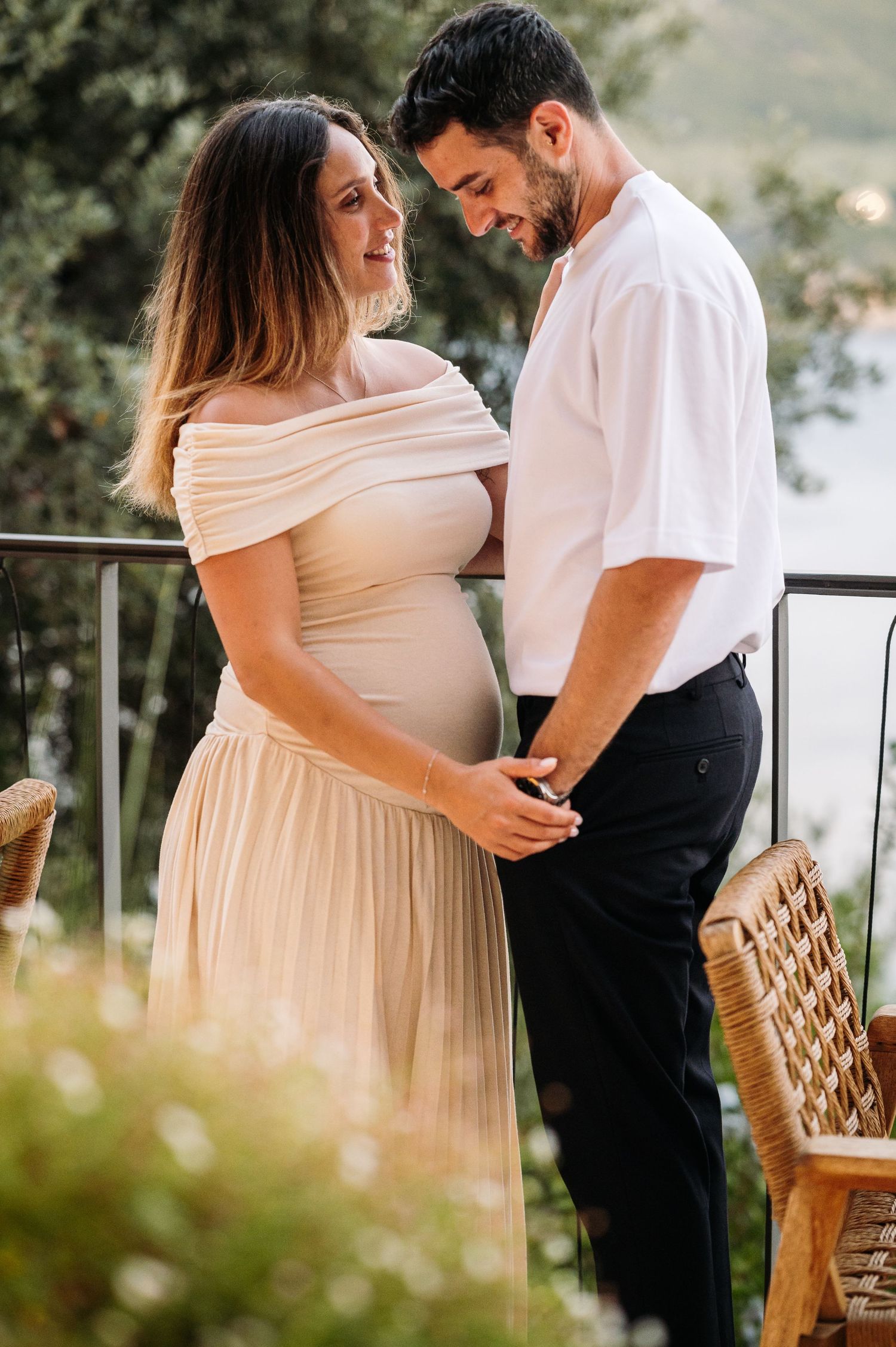 A couple shares tender moments outdoors in a natural setting with soft lighting.