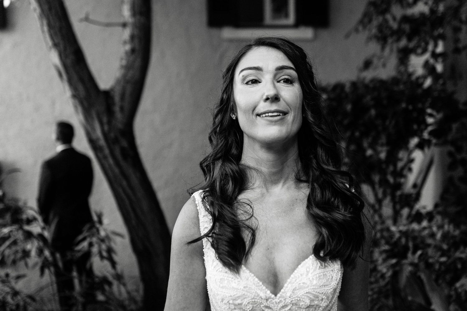 An elegant wedding portrait series captured in black and white against a textured wall.