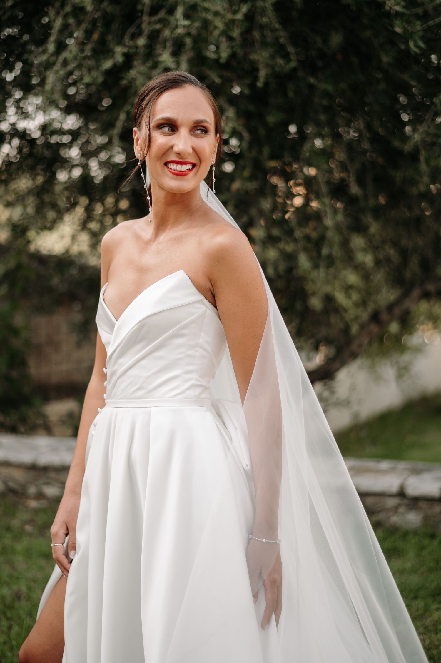 Elegant bridal portraits in a flowing white wedding gown with a sweetheart neckline outdoors.