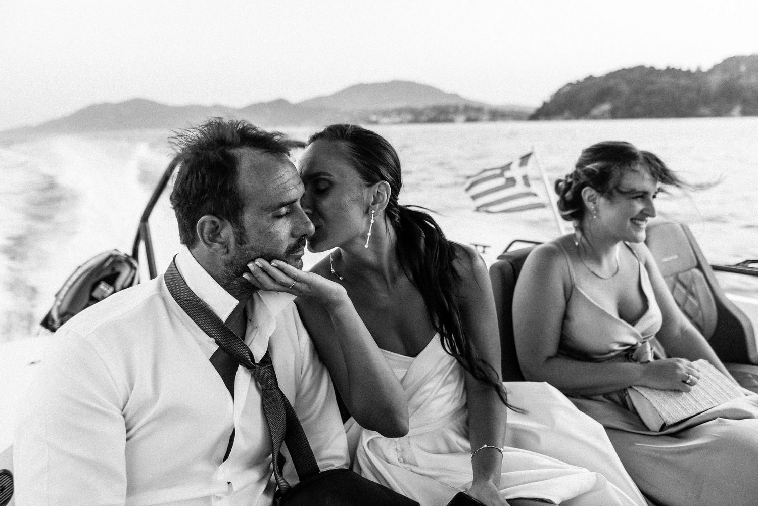 Romantic black and white photo series of a couple embracing on a beach at sunset.