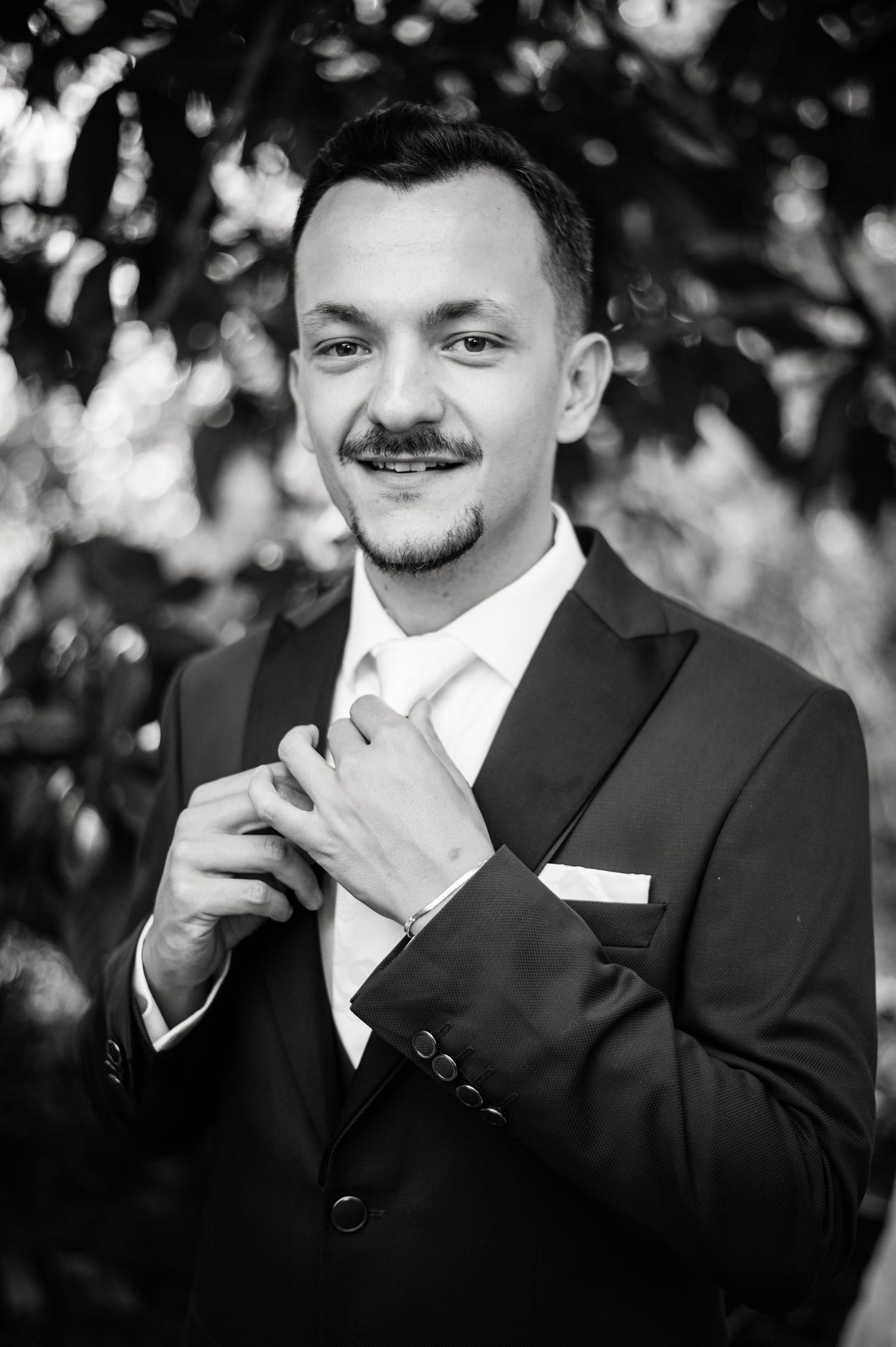 Black and white portrait series showing expressions of joy in formal wedding attire.