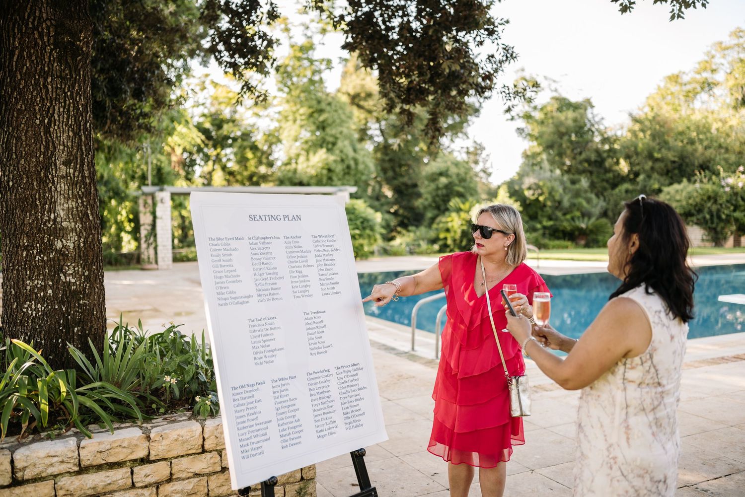 Guests reviewing seating charts and event details posted on outdoor display boards.