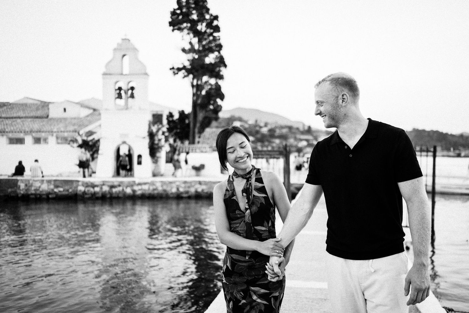 Black and white seaside engagement photos with coastal buildings in background.