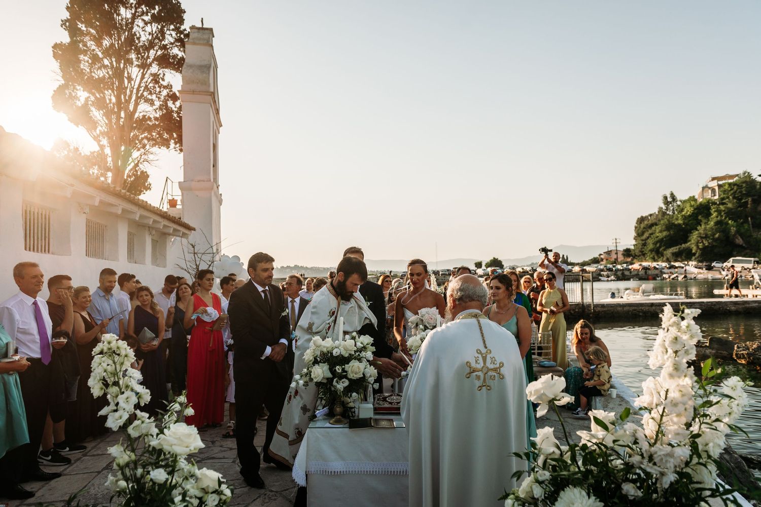 Outdoor wedding reception setup with white decor against Mediterranean architecture.
