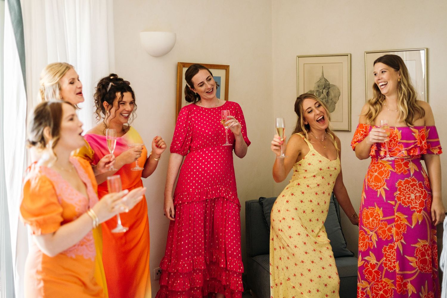 Group gathering in bright summer dresses during wedding preparations.