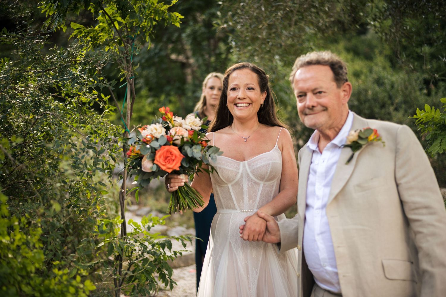 Wedding guests gathered outdoors under trees for a summer celebration.