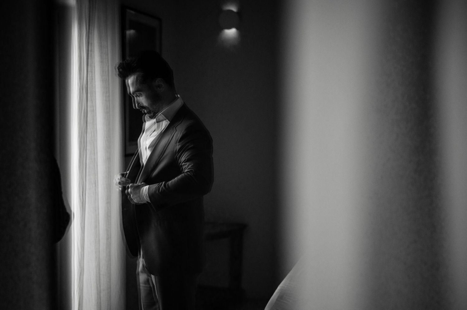 Dramatic black and white portrait showing preparation in window light.