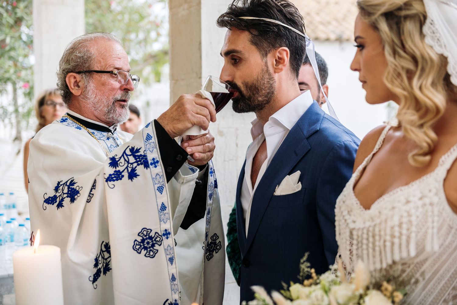 Wedding party gathered outdoors with blue floral details and elegant attire.