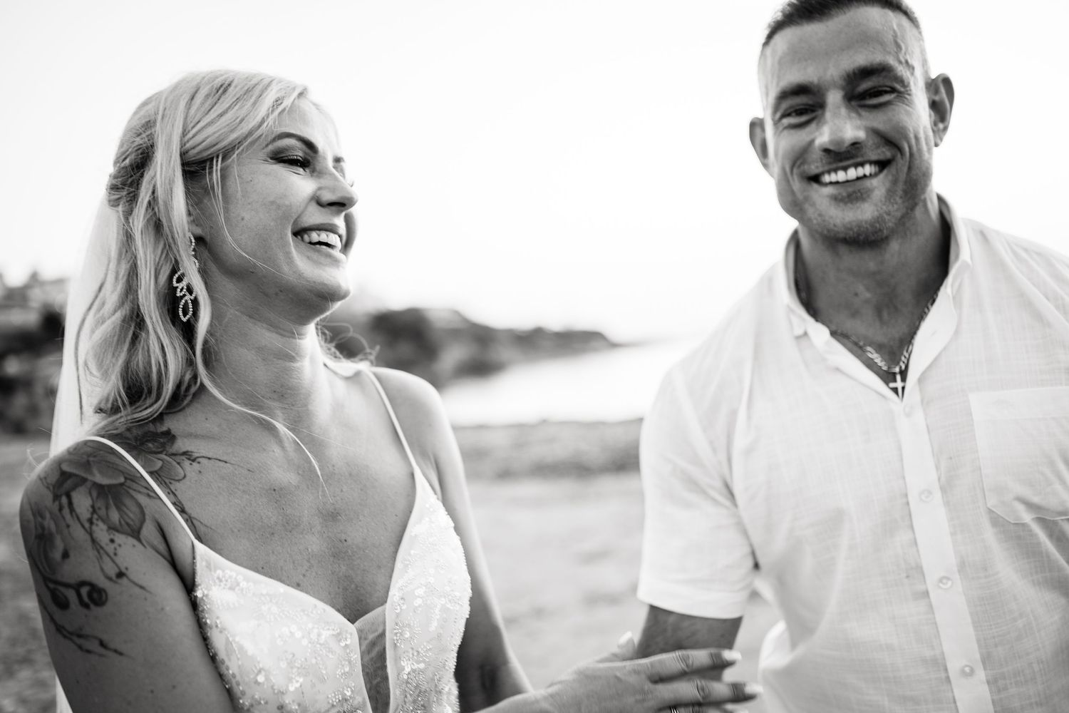 Black and white portraits capturing joyful moments at a seaside wedding celebration.