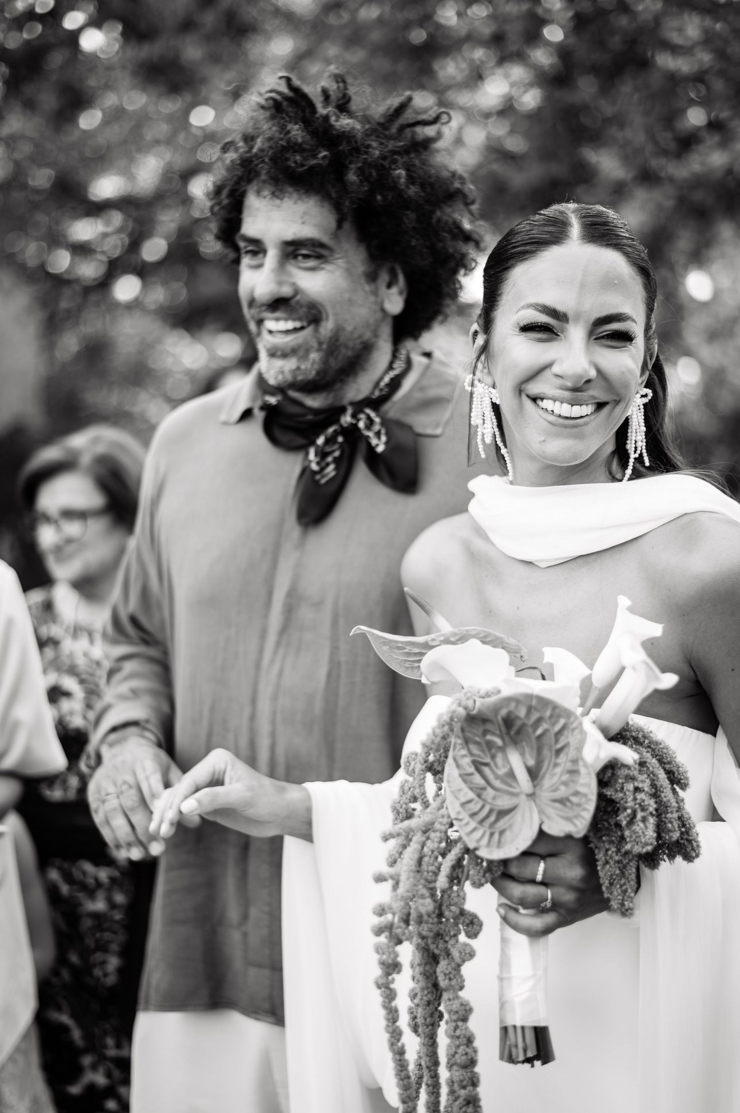 Black and white wedding portrait with bouquet and casual elegant attire.