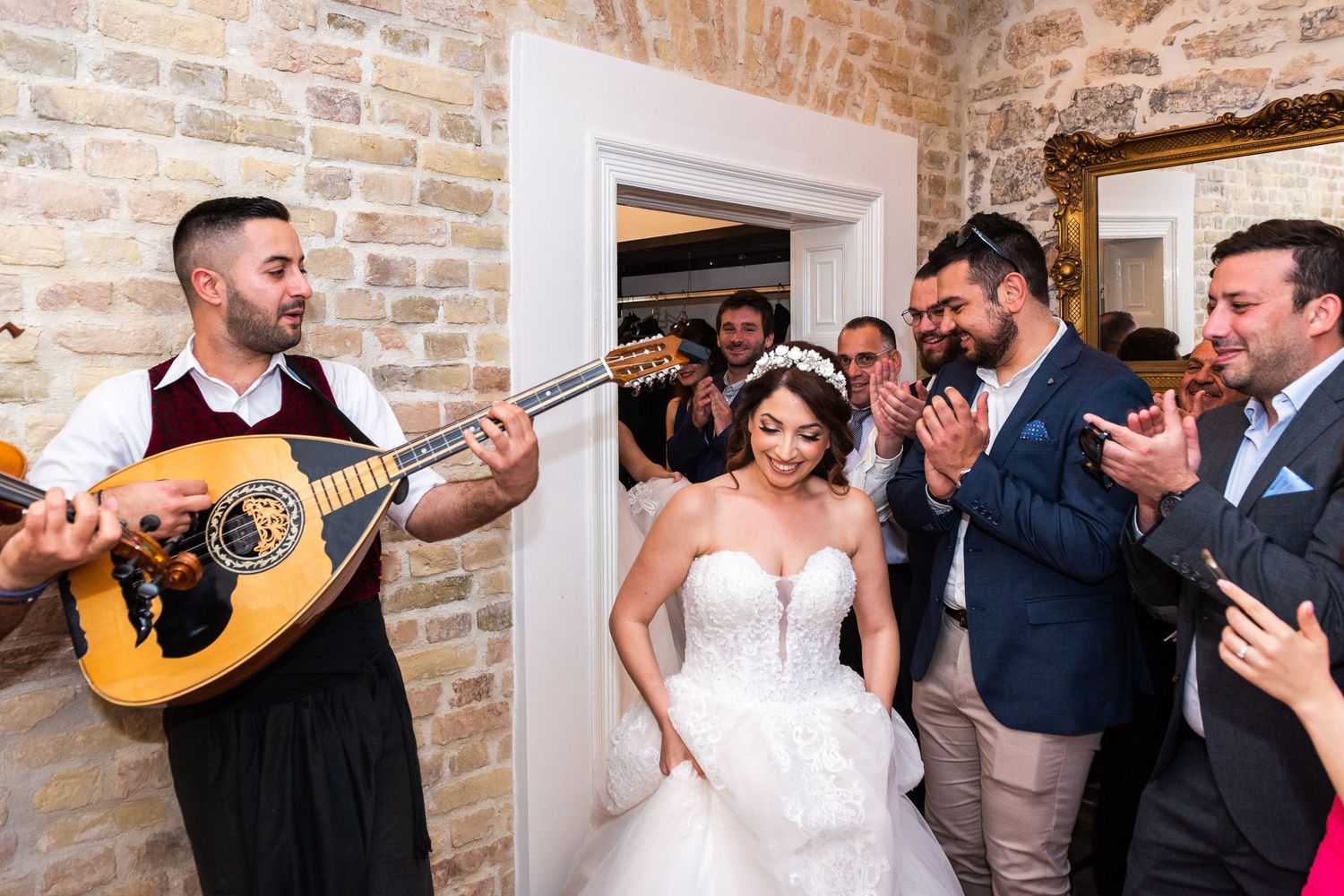 Wedding celebration with acoustic guitar performance and dancing in rustic brick venue.